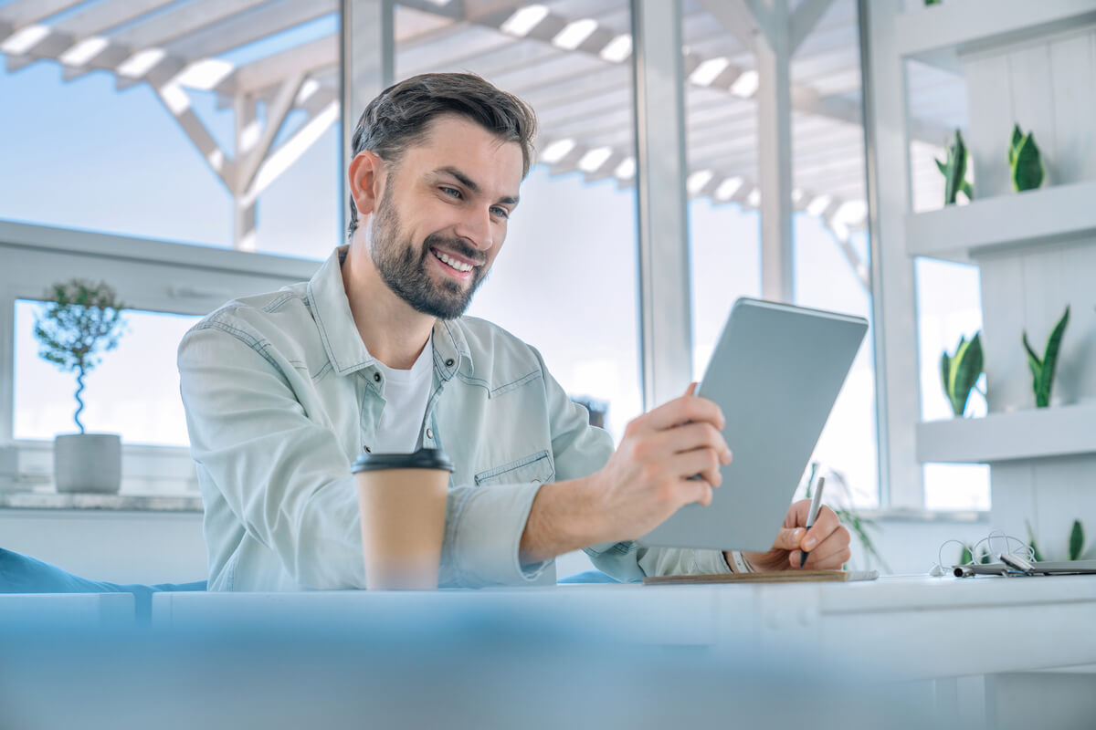 smiling man working on his digital tablet at a cof 2026 03 17 04 01 59 utc.jpg